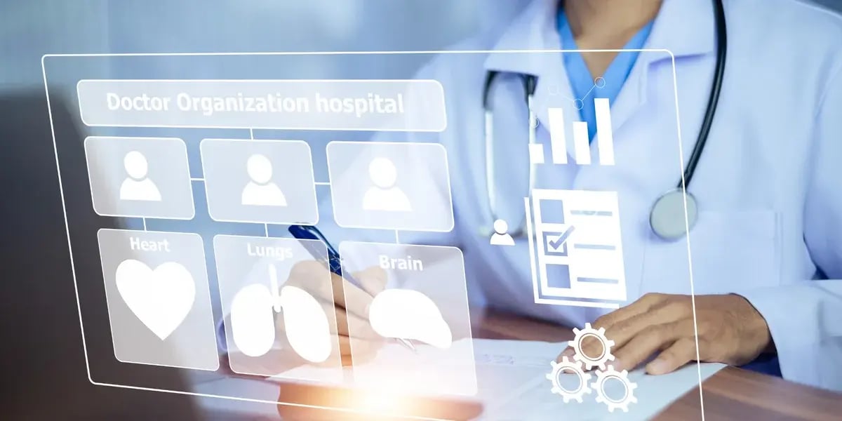 Arzt mit Stethoskop arbeitet am Laptop, während digitale medizinische Symbole und Organisationsgrafiken eingeblendet werden.